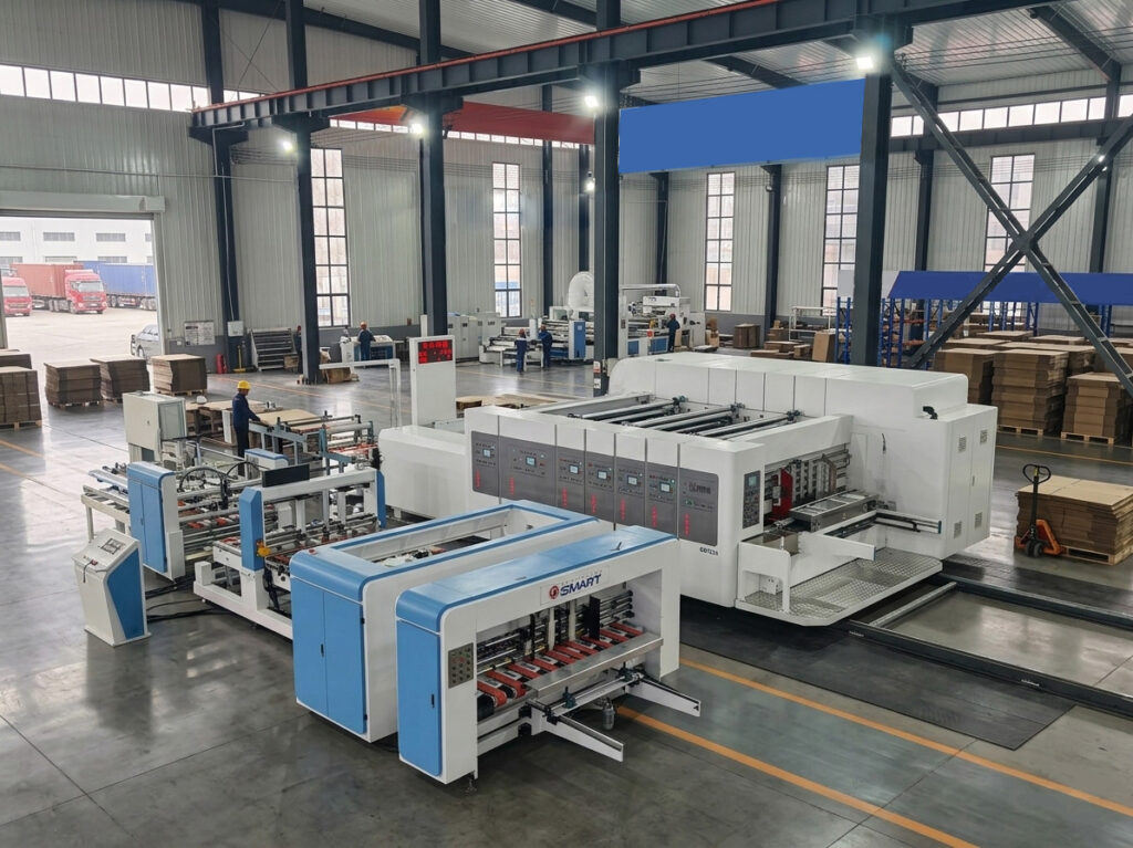 This specialized machinery integrates all three functions—folding and gluing, stitching, and strapping—into a single, cohesive production line, as exemplified by the 'SMART' brand equipment shown. The combination of features ensures unmatched precision, efficiency, and waste reduction, making it an ultimate solution for modern packaging and warehousing. This machine line is eco-certified and designed for sustainable packaging.