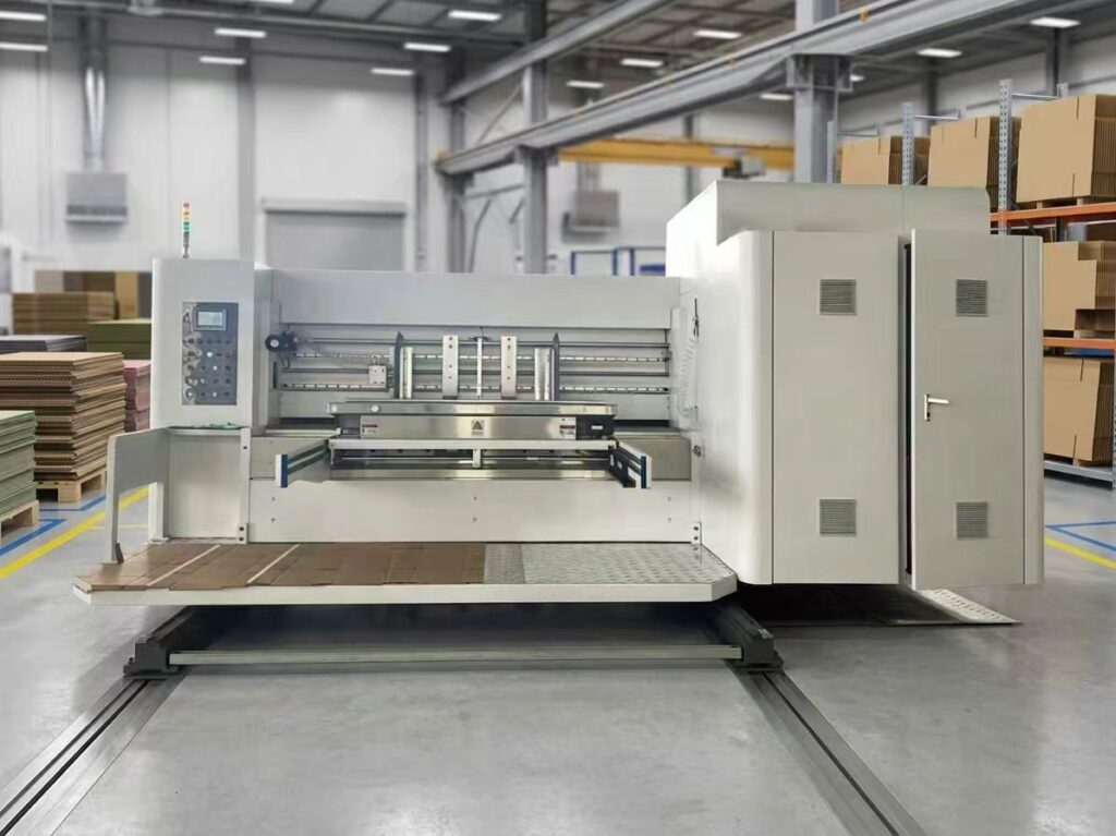 An industrial box printer workstation shown with automated cardboard feeding and control panels